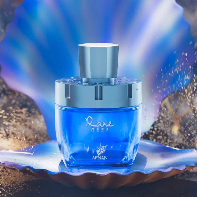 Afnan Rare Reef perfume bottle displayed on a seashell with glowing aquatic reflections.