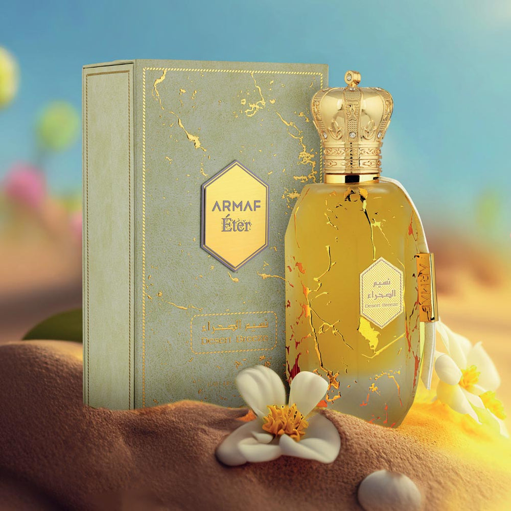 Armaf Desert Breeze perfume from the Éter Collection, royal gold bottle with crown cap on desert-inspired background.