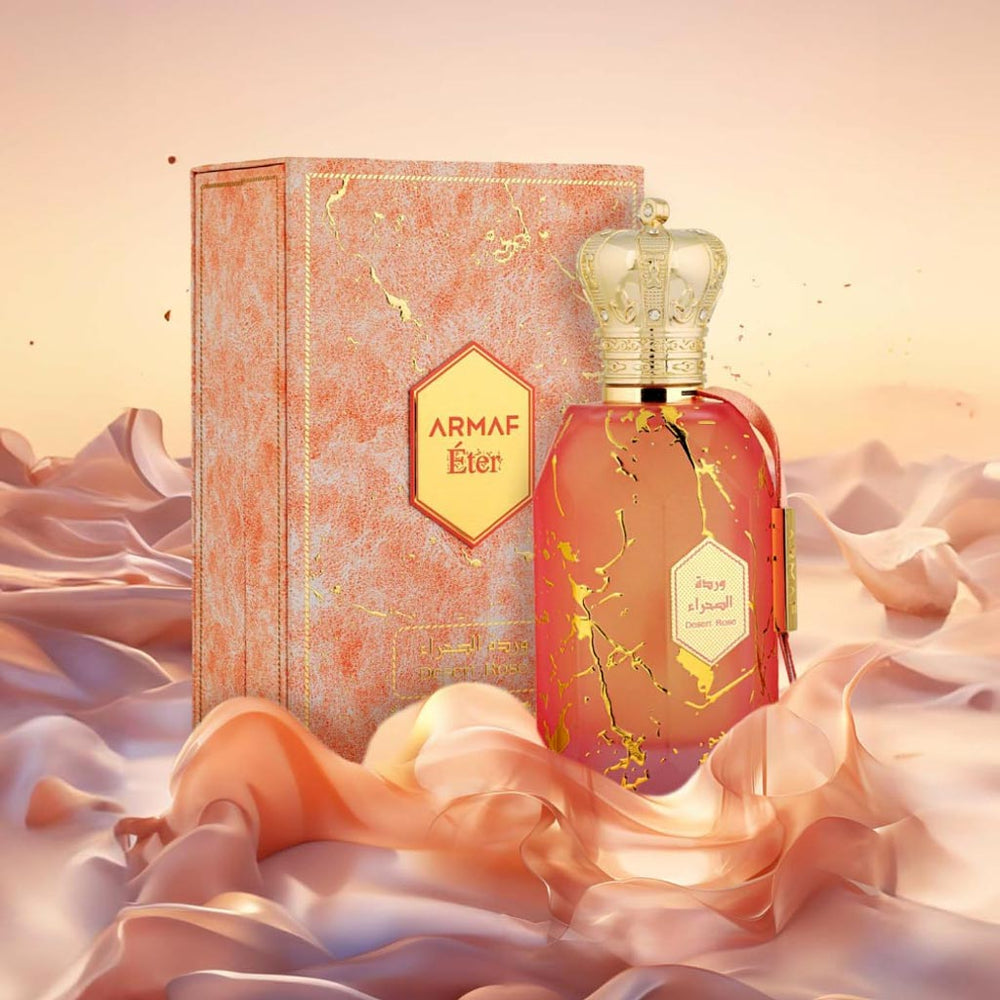 Armaf Desert Rose perfume from the Éter Collection displayed with matching pink box and golden crown cap.